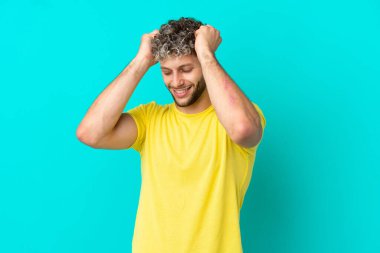 Mavi arka planda izole edilmiş yakışıklı beyaz adam gülüyor.