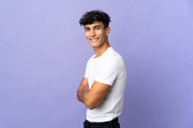 Arjantinli genç adam arka planda izole edilmiş, yana bakıyor ve gülümsüyor.