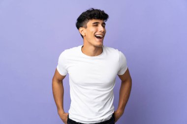 Arjantinli genç adam arka planda yalnız gülüyor.