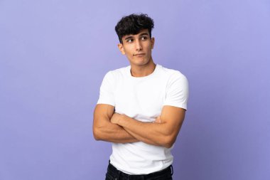 Arjantinli genç adam arka planda izole edilmiş. Omuzlarını kaldırırken şüphe jestleri yapıyor.