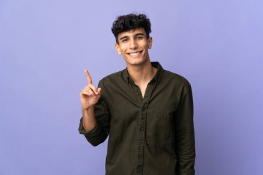 Arjantinli genç adam arka planda izole edilmiş ve en iyinin işareti olarak parmağını kaldırıyor.