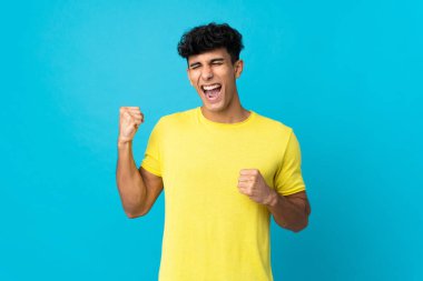 Arjantinli genç adam arka planda izole edilmiş zaferi kutluyor.