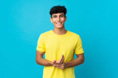 Arjantinli genç adam arka planda yalnız gülüyor.