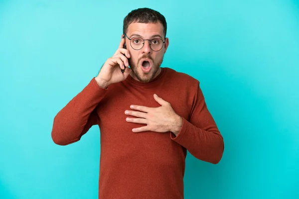 Mladý Brazilský Muž Pomocí Mobilního Telefonu Izolované Modrém Pozadí Překvapen — Stock fotografie