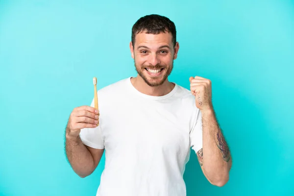 Young Brazilian Man Brushing Teeth Isolated Blue Background Celebrating Victory — Stockfoto