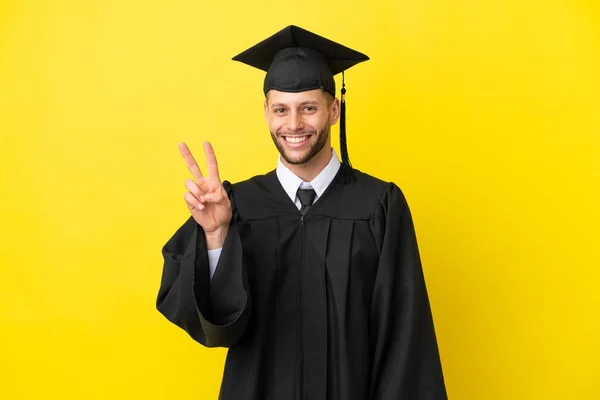Молодий Випускник Університету Кавказький Чоловік Ізольований Жовтому Тлі Посміхаючись Показуючи — стокове фото