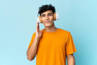 Arjantinli genç adam arka planda izole edilmiş müzik dinliyor.