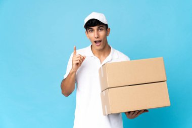Teslimatçı Arjantinli adam mavi arka planda tek parmağını kaldırarak çözümü bulmaya çalışıyor.