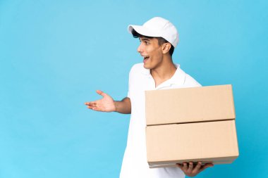 Teslimatçı Arjantinli adam mavi arka planda, yana bakarken sürpriz bir ifadeyle izole edilmiş.