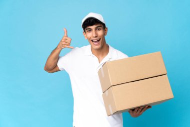 Arjantinli adam mavi arka planda izole edilmiş bir şekilde telefon jesti yapıyor. Bana geri dönüş işareti ver.