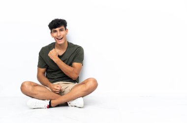 Genç Arjantinli adam yerde oturmuş zaferi kutluyor.