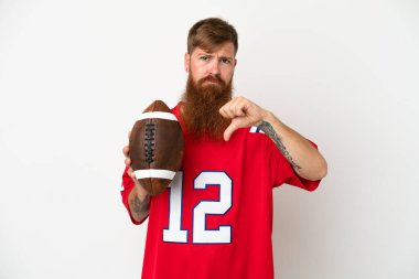 Beyaz arka planda ragbi oynayan Kafkasyalı genç adam olumsuz ifadeyle baş parmağını aşağı gösteriyor.