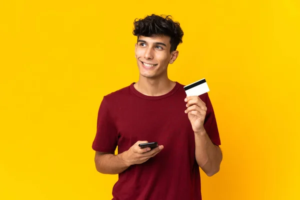 Νεαρός Αργεντινός Άνδρας Απομονωμένος Κίτρινο Φόντο Αγοράζει Κινητό Πιστωτική Κάρτα — Φωτογραφία Αρχείου
