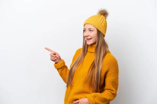 白地に冬のジャケットを着た若い白人女性が指を横に向けて製品を提示する — ストック写真