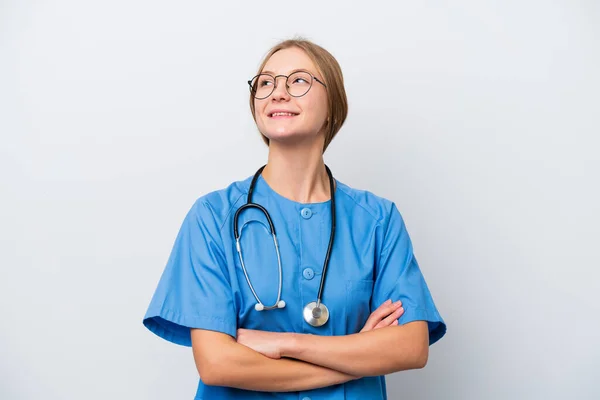 笑顔で見上げながら白い背景に孤立した若い看護師の医師の女性 — ストック写真