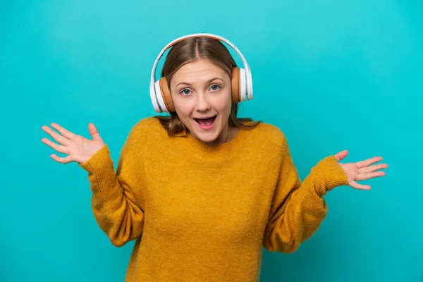Jonge Russische Vrouw Geïsoleerd Blauwe Achtergrond Verrast Luisteren Muziek — Stockfoto