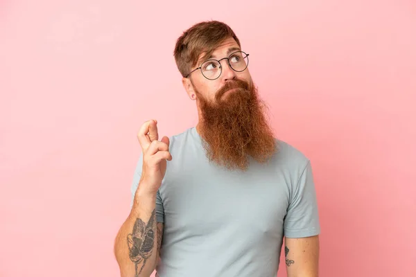 Young Reddish Caucasian Man Isolated Pink Background Fingers Crossing Wishing — Stock Photo, Image