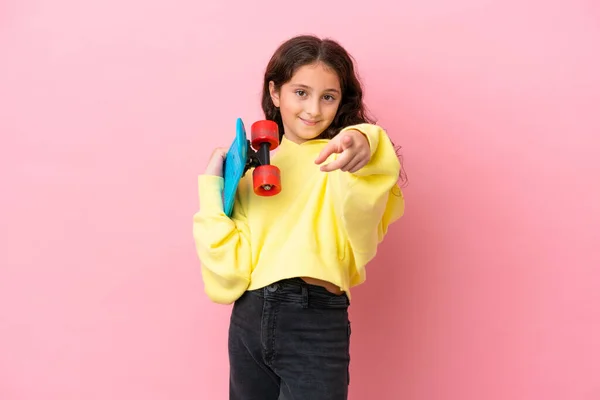 Pequena Menina Caucasiana Isolado Fundo Rosa Com Patinador Apontando Para — Fotografia de Stock