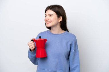 Beyaz arka planda izole edilmiş kahve makinesini tutan genç Rus kadın.