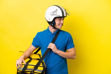 Sırt çantalı genç Brezilyalı adam sarı arka planda izole edilmiş.