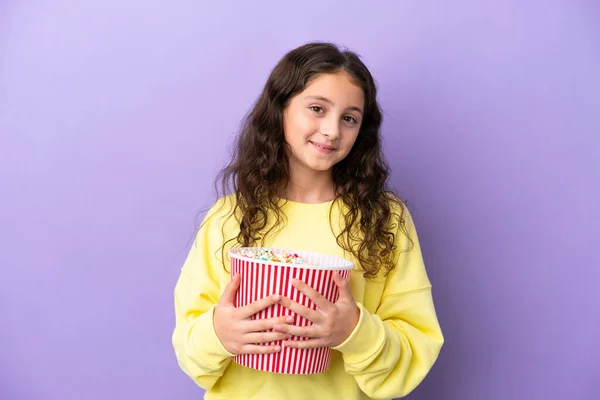 Little Caucasian Girl Isolated Purple Background Holding Big Bucket Popcorns — Stockfoto