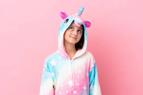 Niña Caucásica Usando Pijama Unicornio Aislado Sobre Fondo Rosa Pensando —  Fotos de Stock