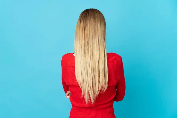 Jovem Loira Isolada Fundo Azul Posição Traseira — Fotografia de Stock