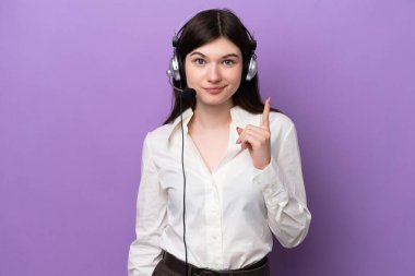 Mor arka planda izole edilmiş kulaklıkla çalışan pazarlamacı Rus kadın işaret parmağıyla işaret etmek harika bir fikir.