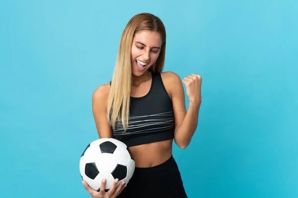 Молодая Блондинка Синем Фоне Футбольным Мячом Празднующим Победу — стоковое фото