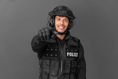 Özel Tim 'in beyaz adamı gri arka planda izole edilmiş. Parmağını kendine güvenen bir ifadeyle sana doğrultuyor.