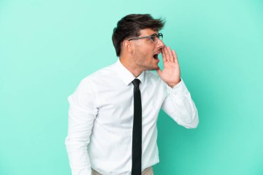 Mavi arka planda izole edilmiş beyaz bir adam ağzı sonuna kadar açık bağırıyor.