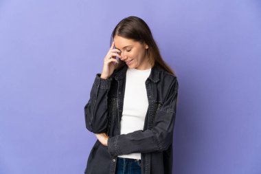 Genç Litvanyalı kadın, mor arka planda izole edilmiş gülüyor.