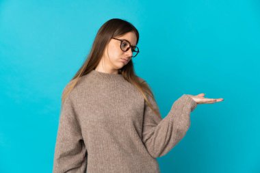 Genç Litvanyalı bir kadın mavi arka planda izole edilmiş.