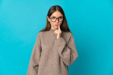 Genç Litvanyalı kadın mavi arka planda izole edilmiş ve düşünüyor