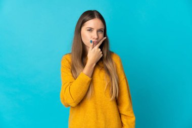 Genç Litvanyalı kadın mavi arka planda izole edilmiş. Şüpheleri var.