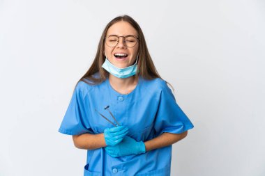 Litvanyalı kadın diş hekimi izole edilmiş arka planda aletleri tutarken gülümsüyor.