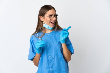 Litvanyalı kadın diş hekimi, arka planda izole edilmiş aletleri tutarken, çözümü fark etmek için parmağını kaldırıyor.