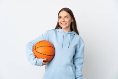 Basketbol oynayan Litvanyalı genç bir kadın beyaz arka planda izole edilmiş bir şekilde yukarı bakarken bir fikir düşünüyor.