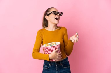 Genç Litvanyalı bir kadın pembe arka planda gözlüklü ve elinde koca bir kova patlamış mısır tutuyordu.