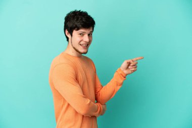 Genç Rus adam mavi arka planda izole edildi.