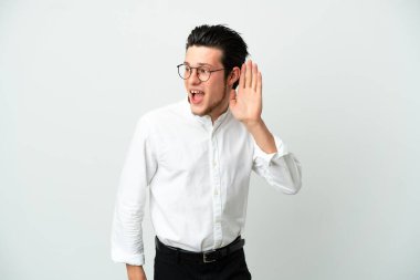 Rus iş adamı beyaz arka planda izole edilmiş bir şekilde bir şeyler dinlerken elini kulağına koyar.