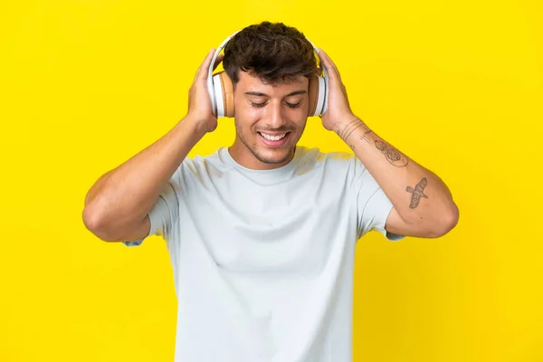 Νεαρός Καυκάσιος Όμορφος Άνδρας Απομονωμένος Κίτρινο Φόντο Ακούγοντας Μουσική — Φωτογραφία Αρχείου