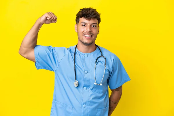 Mladý Chirurg Lékař Muž Izolované Žlutém Pozadí Dělá Silné Gesto — Stock fotografie