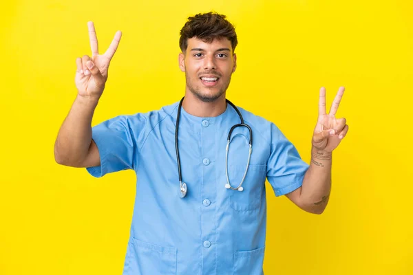 Mladý Chirurg Lékař Muž Izolované Žlutém Pozadí Ukazující Vítězství Znamení — Stock fotografie