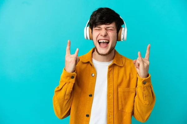 Jovem Russo Homem Isolado Fundo Azul Ouvir Música Fazendo Gesto — Fotografia de Stock