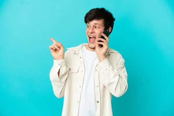 Young Russian Man Using Mobile Phone Isolated Blue Background Intending — 图库照片