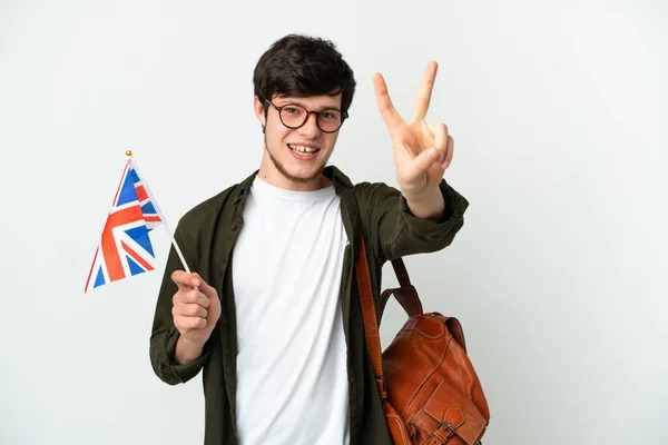 Mladý Rus Drží Vlajku Spojeného Království Izolované Bílém Pozadí Úsměvem — Stock fotografie