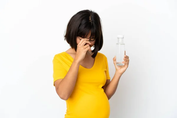 白い背景に孤立した水のボトルを持っている若い妊婦は笑って — ストック写真