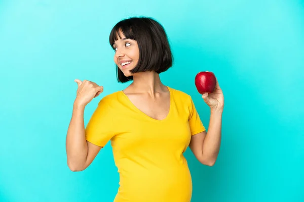 Schwangere Mit Einem Apfel Auf Blauem Hintergrund Der Zur Seite — Stockfoto