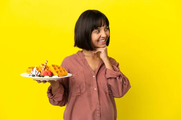 Pregnant Woman Holding Waffles Isolated Yellow Background Looking While Smiling — Foto Stock